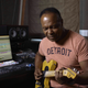 Ray Parker Jr. plays guitar in front of a computer.